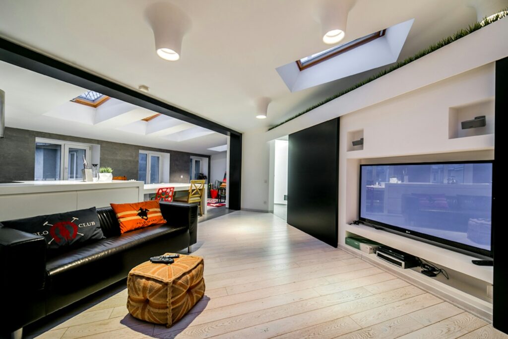 a living room with a black couch and a flat screen tv