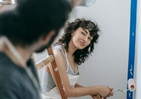 A couple enjoying painting their new home together, creating a vibrant and cozy space.