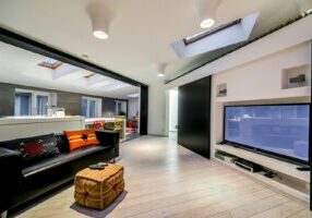 a living room with a black couch and a flat screen tv